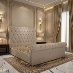 Beige upholstered sleigh bed with a tall diamond-buttoned headboard, matching rolled footboard, decorative stud edging and a wooden slatted base no mattress
