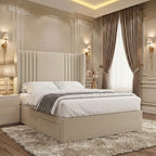 Cream upholstered divan bed with a tall winged headboard, smooth central panel and symmetrical vertical fluted detailing.
