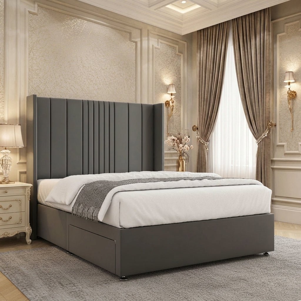 Dark grey upholstered divan bed with a tall winged headboard, broad vertical panels and narrow channel detailing.
