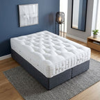 An angled view of the luxury white mattress showing its deeply tufted top, cushioned side panels, ventilation eyelets and convenient positioning handles.