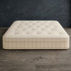 Front view of the cream Dreamnap Hybrid Mattress with a deeply tufted top and quilted side panels.