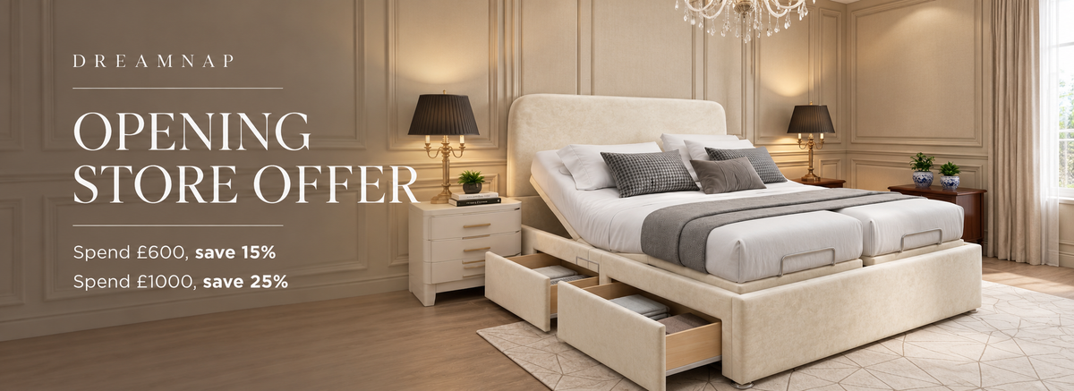 An adjustable cream-colored platform bed with built-in drawers, styled in a luxurious beige bedroom with two matching nightstands, lamps, and a chandelier. Promotional text on the left reads 'DREAMNAP OPENING STORE OFFER'.