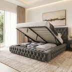 A modern upholstered bed with a tufted gray base and headboard, shown with the lift-up mattress platform open to reveal the interior storage space. The bed is styled with neutral-toned bedding in a bright, contemporary bedroom with a textured rug, curtains, and wall art.