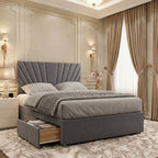 Grey sunburst-headboard divan bed displaying an open side drawer for storing bedding and bedroom essentials.
